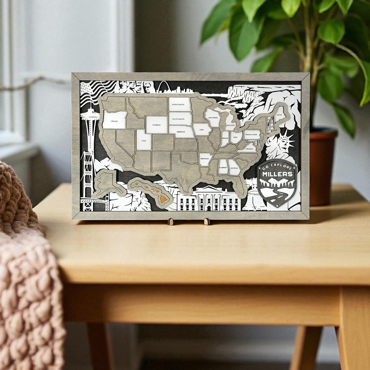 Framed map of the United States with decorative elements on a wall above a wooden desk.