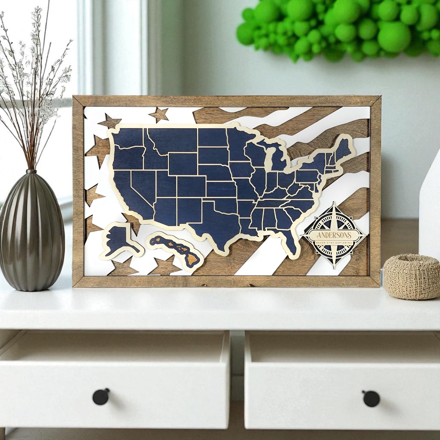 Wooden framed map of the United States with a personalized nameplate on a wall above a desk.