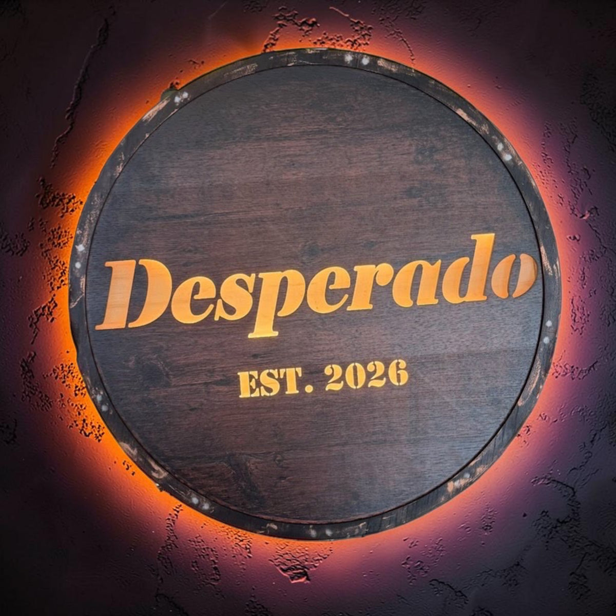 Wooden barrel with 'Desperado EST. 2026' text on a dark background