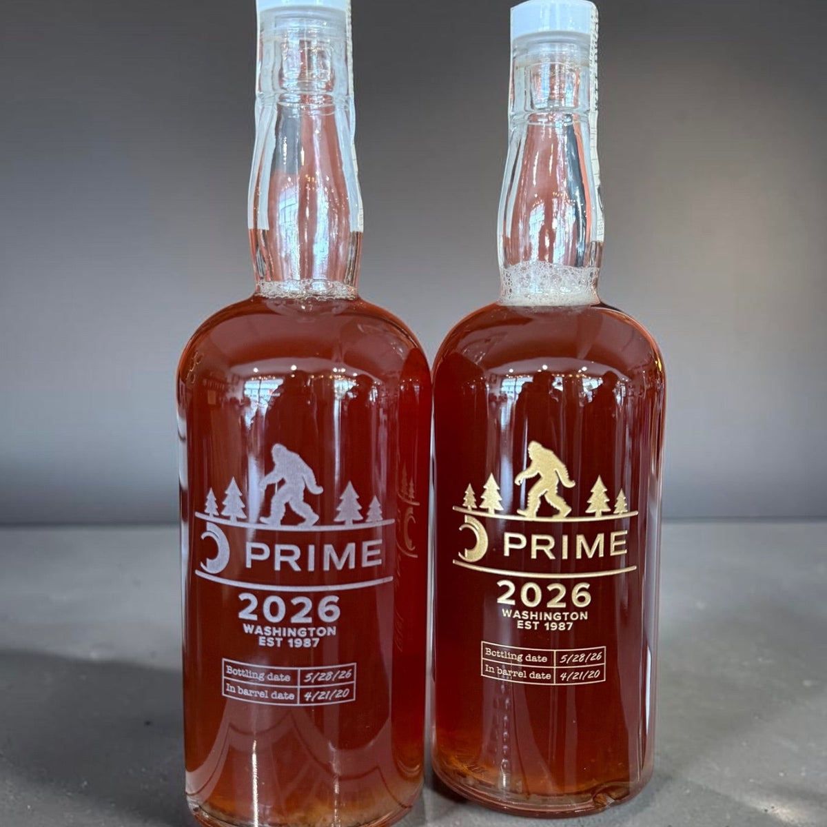 Two bottles of Prime 2026 Washington beer on a gray background