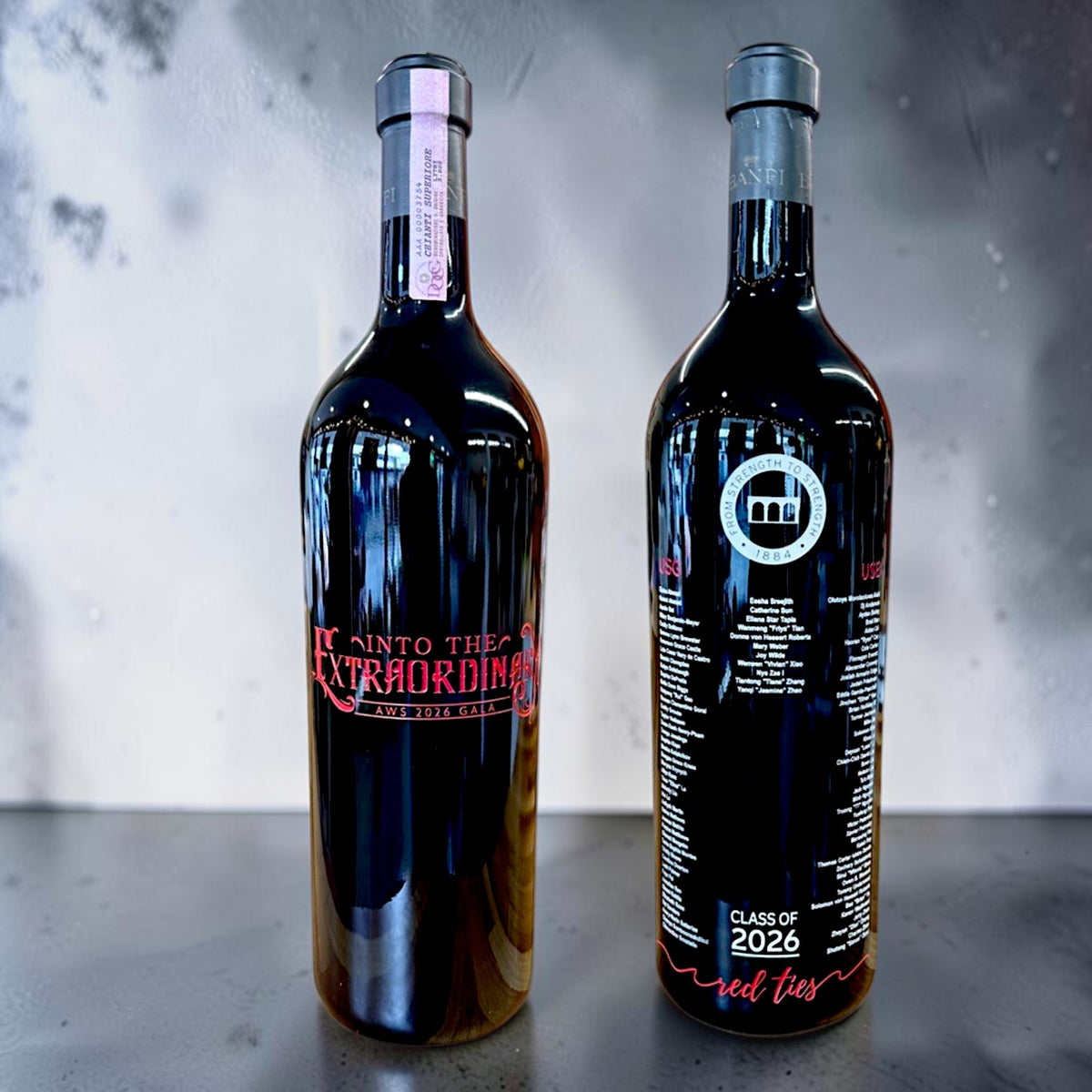 Two wine bottles with labels on a reflective surface and gray background