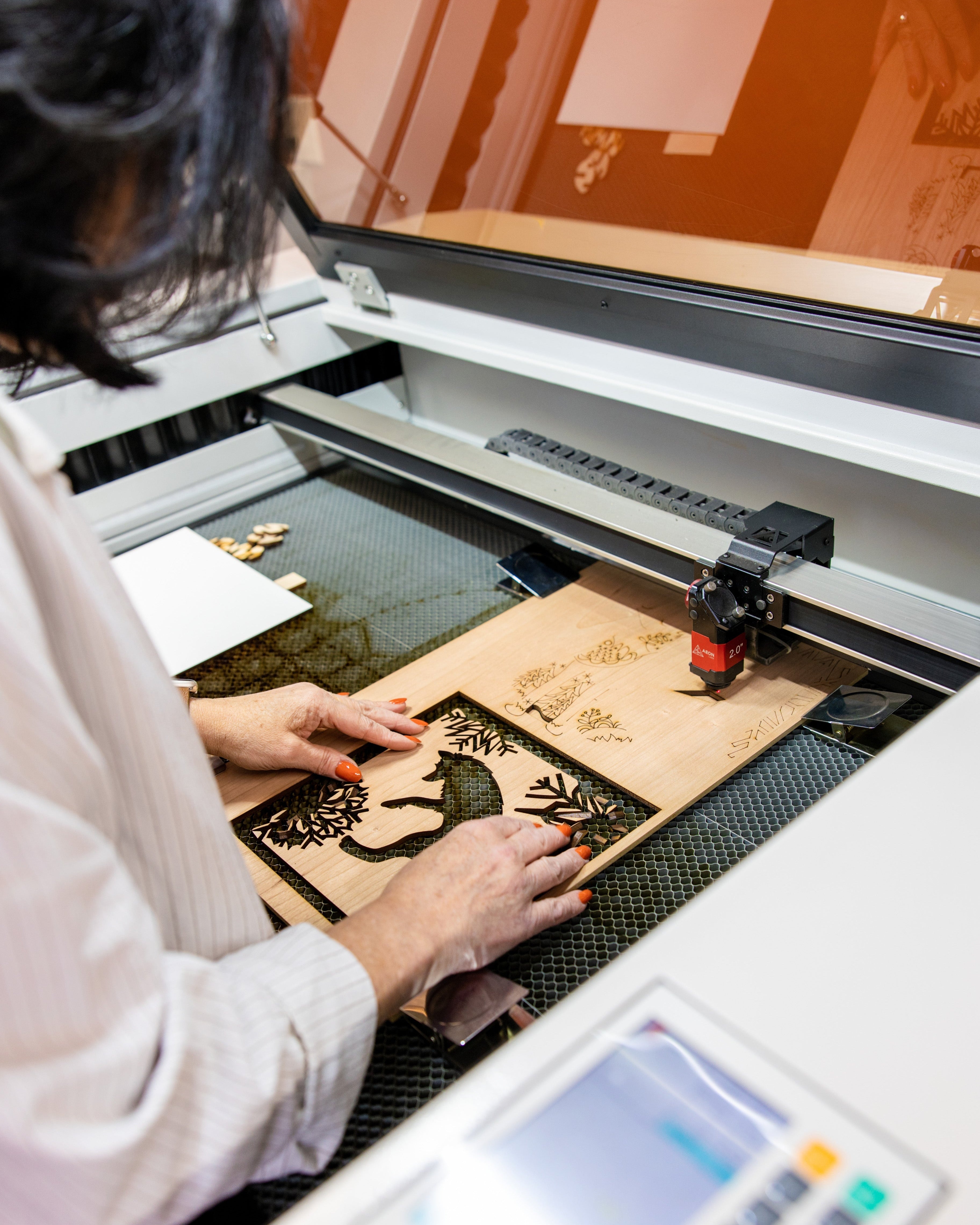 Laser engraving a custom wood piece inside the Foxwood Engraving studio, combining technical precision with craftsmanship
