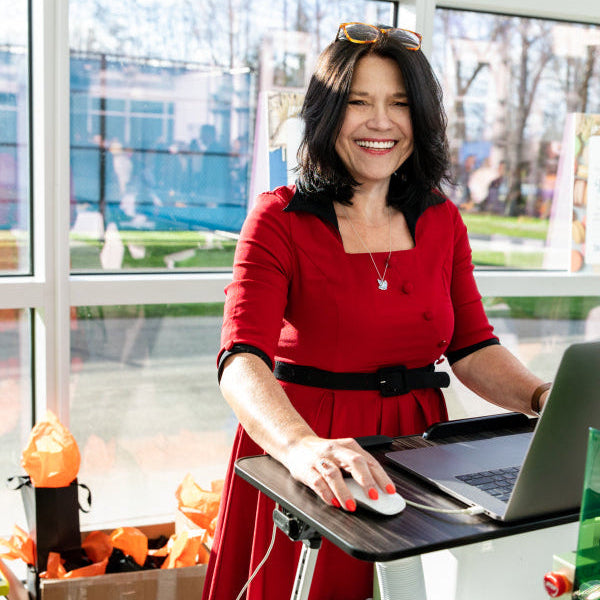 Owner of Foxwood Engraving standing behind desk setting up files for engraving