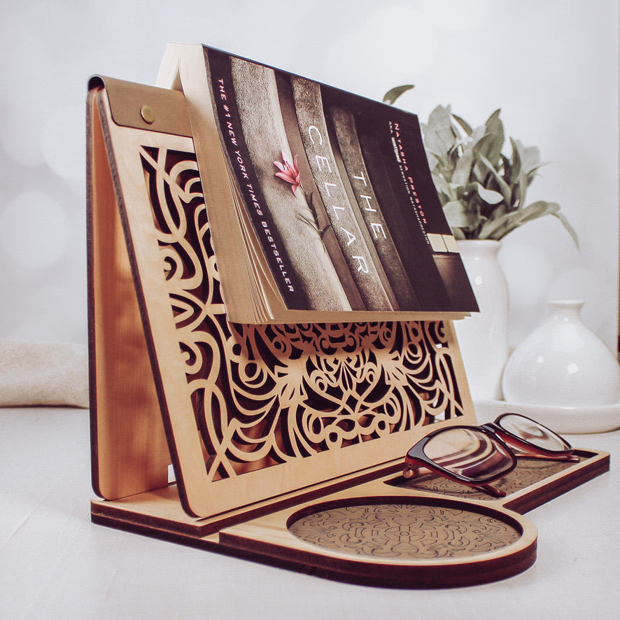 Adjustable wooden book holder with engraved panel displayed with open book