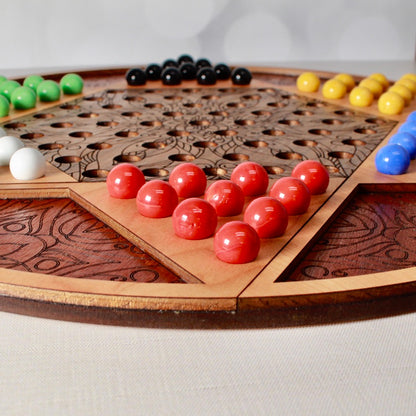 Artisan-crafted wooden Chinese Checkers game with colorful glass marbles.