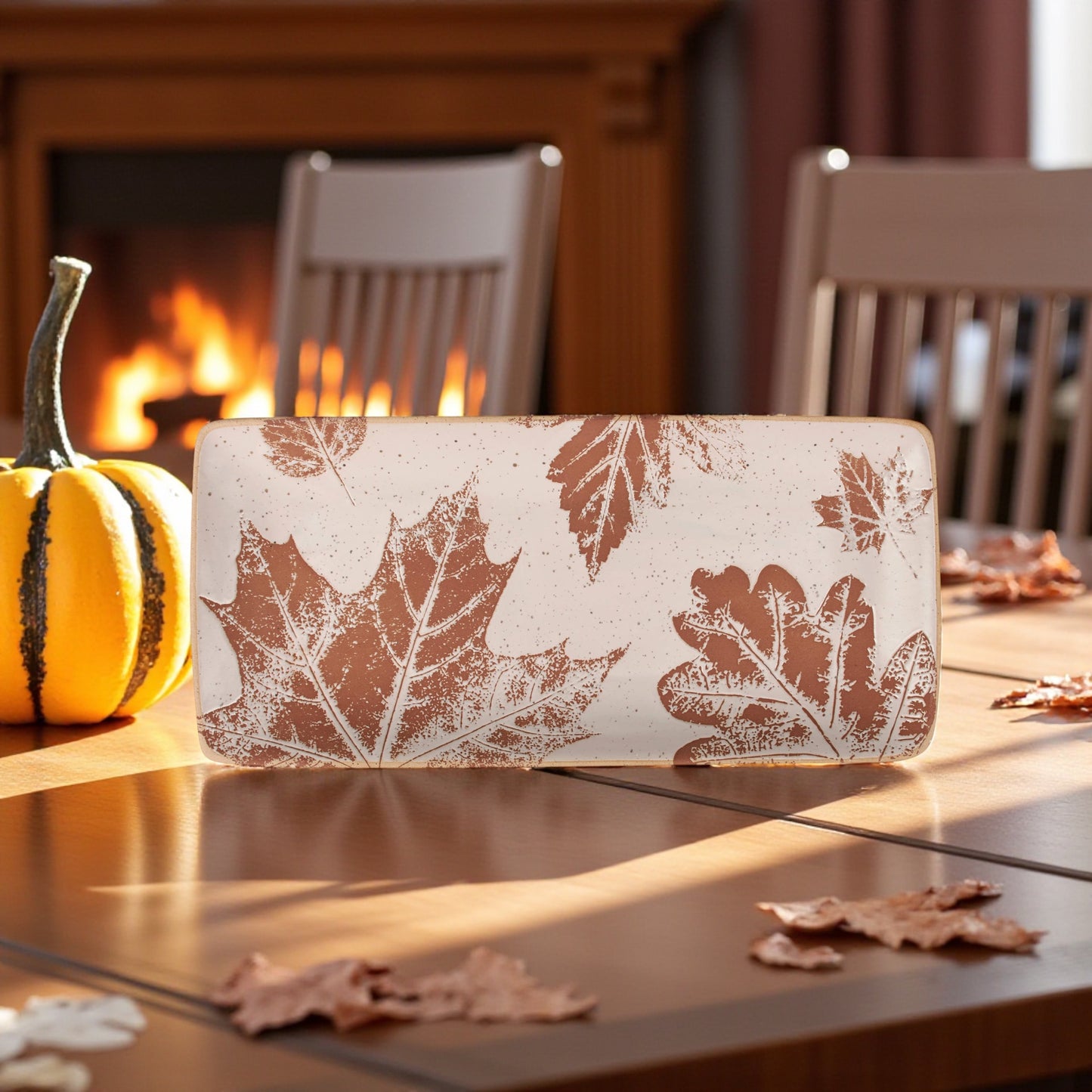 Cream ceramic platter with debossed fall leaf pattern.