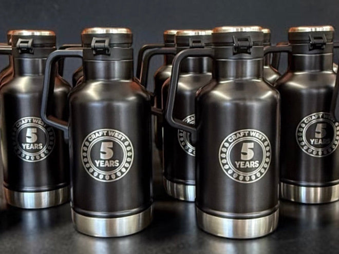 Custom branded drinkware including tumblers, mugs, wine glasses, and water bottles personalized with company logos.