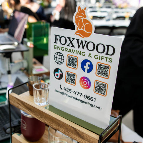 Custom business counter sign featuring the Foxwood logo, contact information, social icons and QR codes.