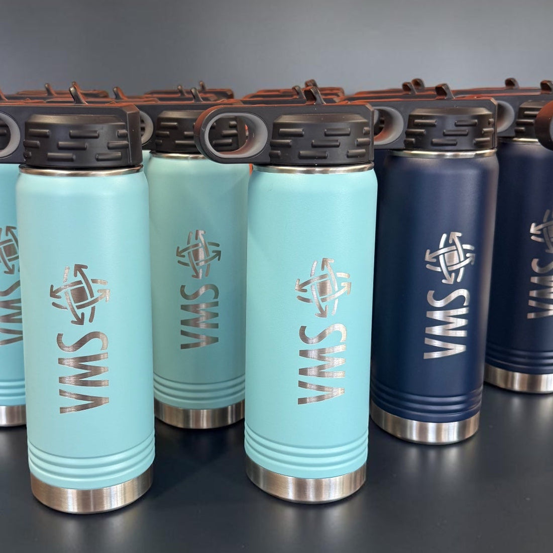 Stainless steel water bottles featuring logo that reads 'VMS' with a compass design.