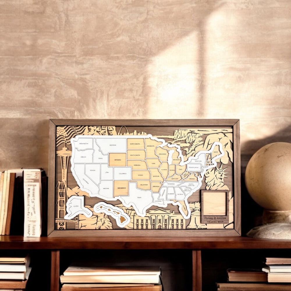 Wooden framed map of the United States on a wooden shelf with books and a globe.