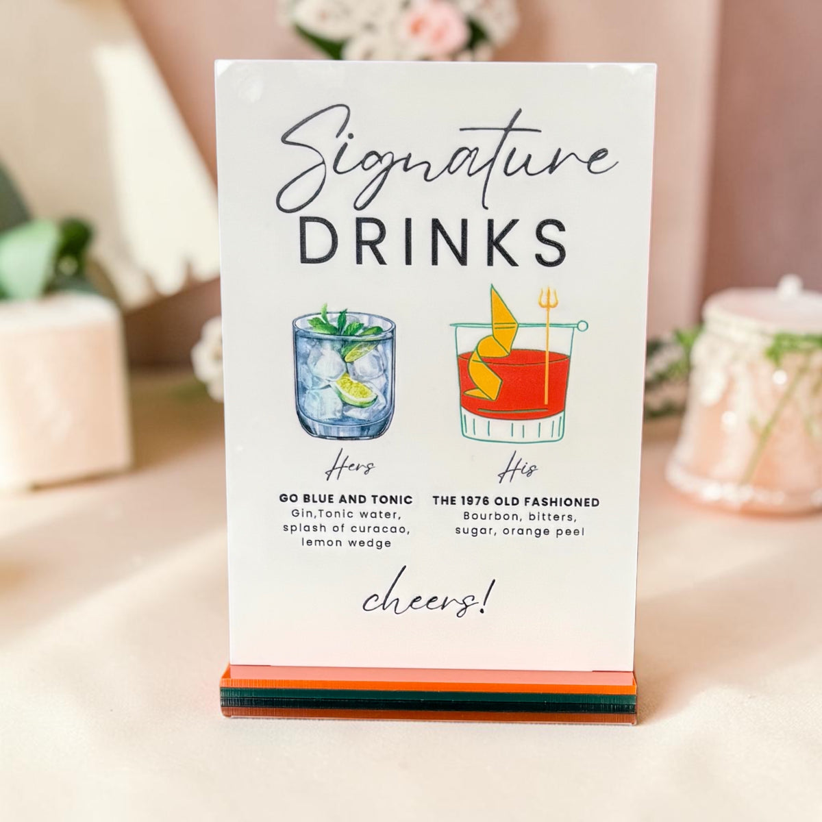 Custom full-color wedding bar sign featuring illustrated his-and-hers signature cocktails on a layered display base.