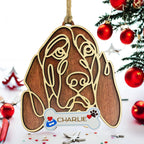 Wooden dog ornament with line-art design hanging on Christmas tree.