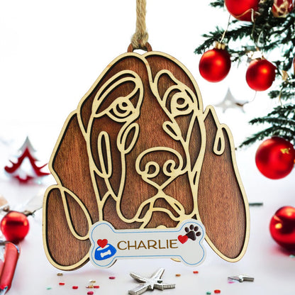 Wooden dog ornament with line-art design hanging on Christmas tree.