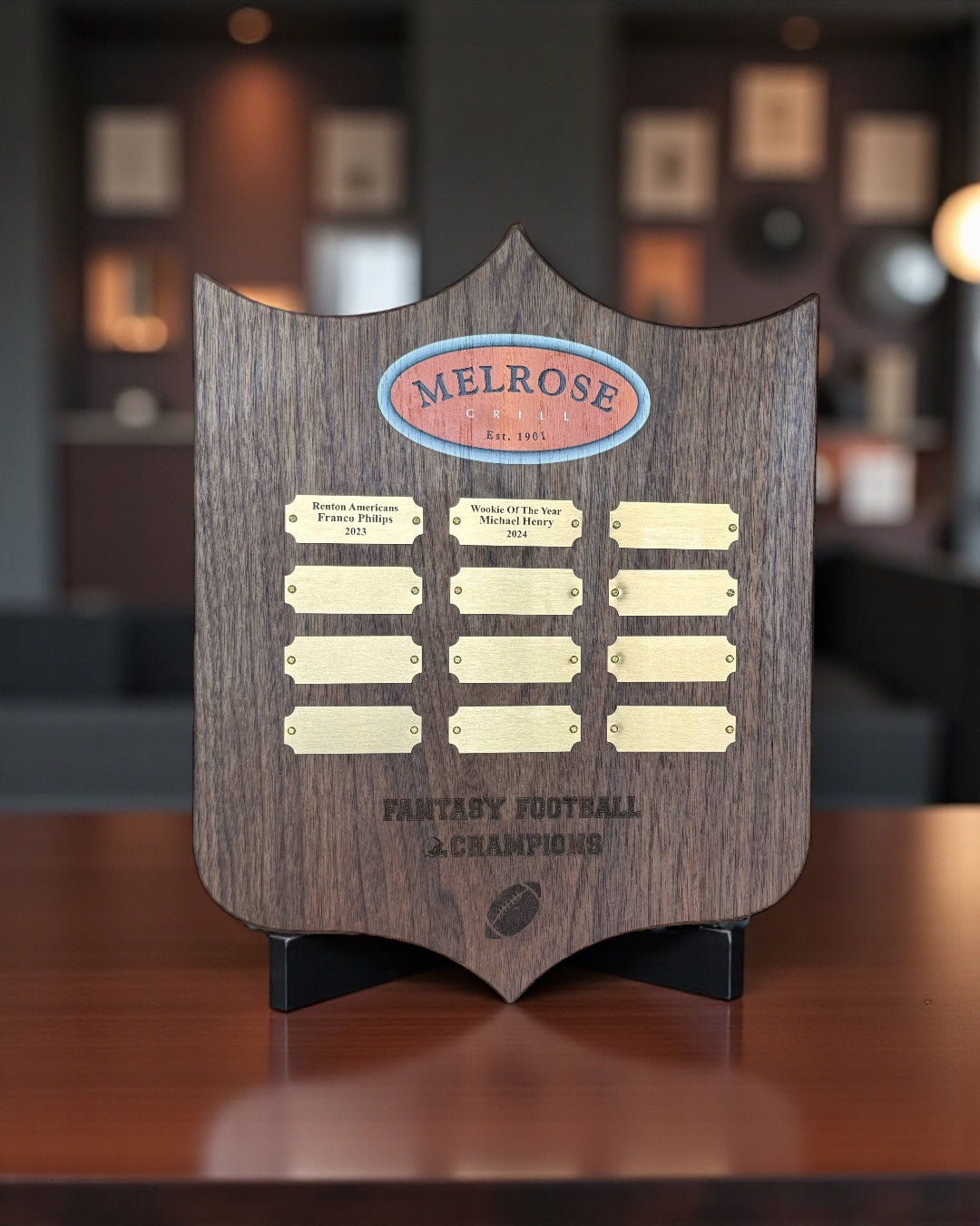 Custom shield-shaped perpetual award plaque with engraved nameplates