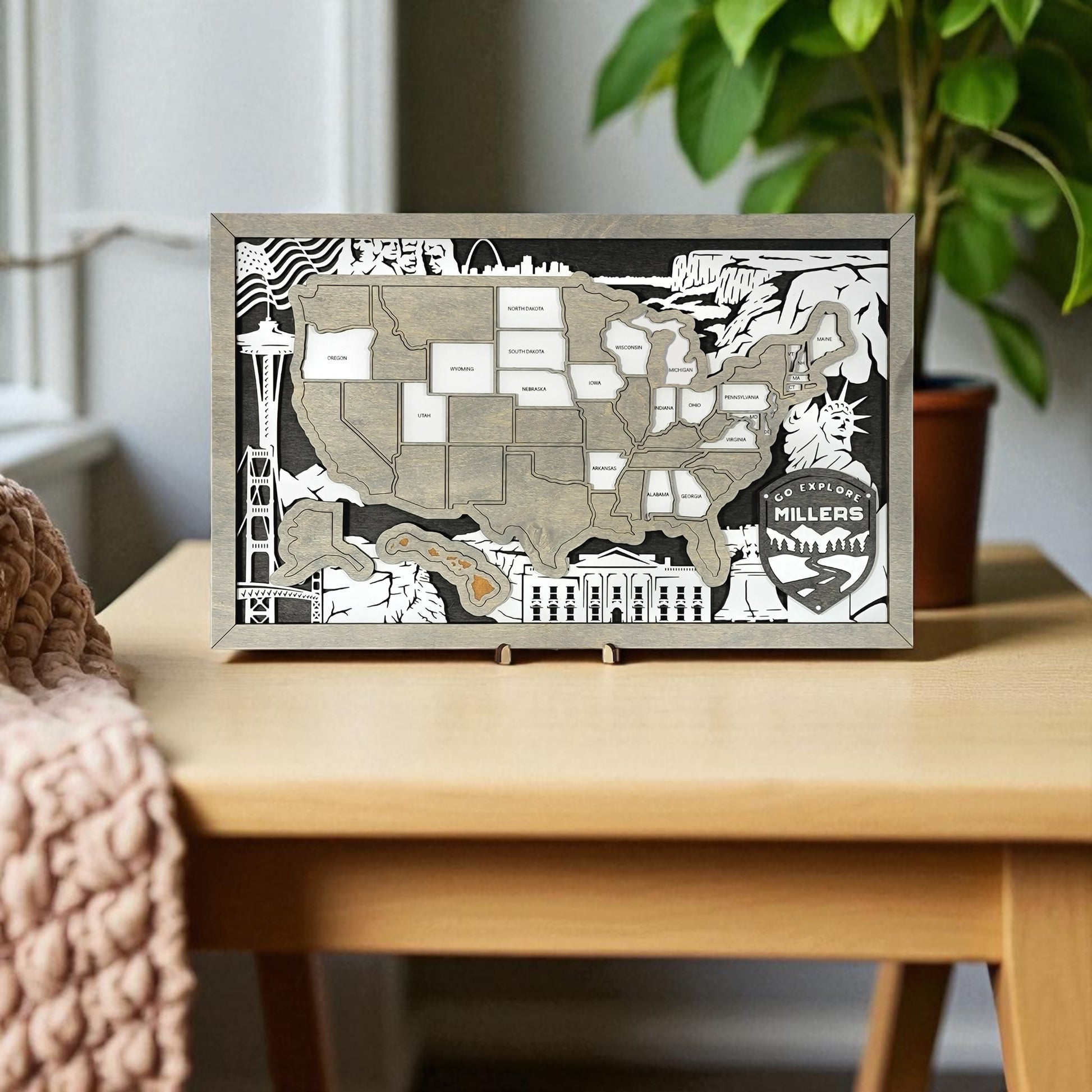 Framed map of the United States with decorative elements on a wall above a wooden desk.