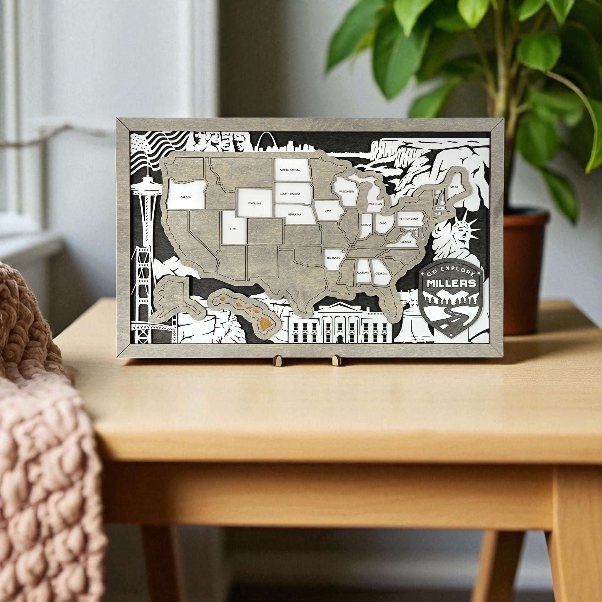 Framed map of the United States with decorative elements on a wall above a wooden desk.