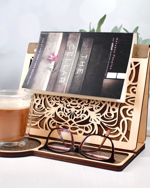 Laser engraved wooden book stand shown in birch wood with decorative reading design
