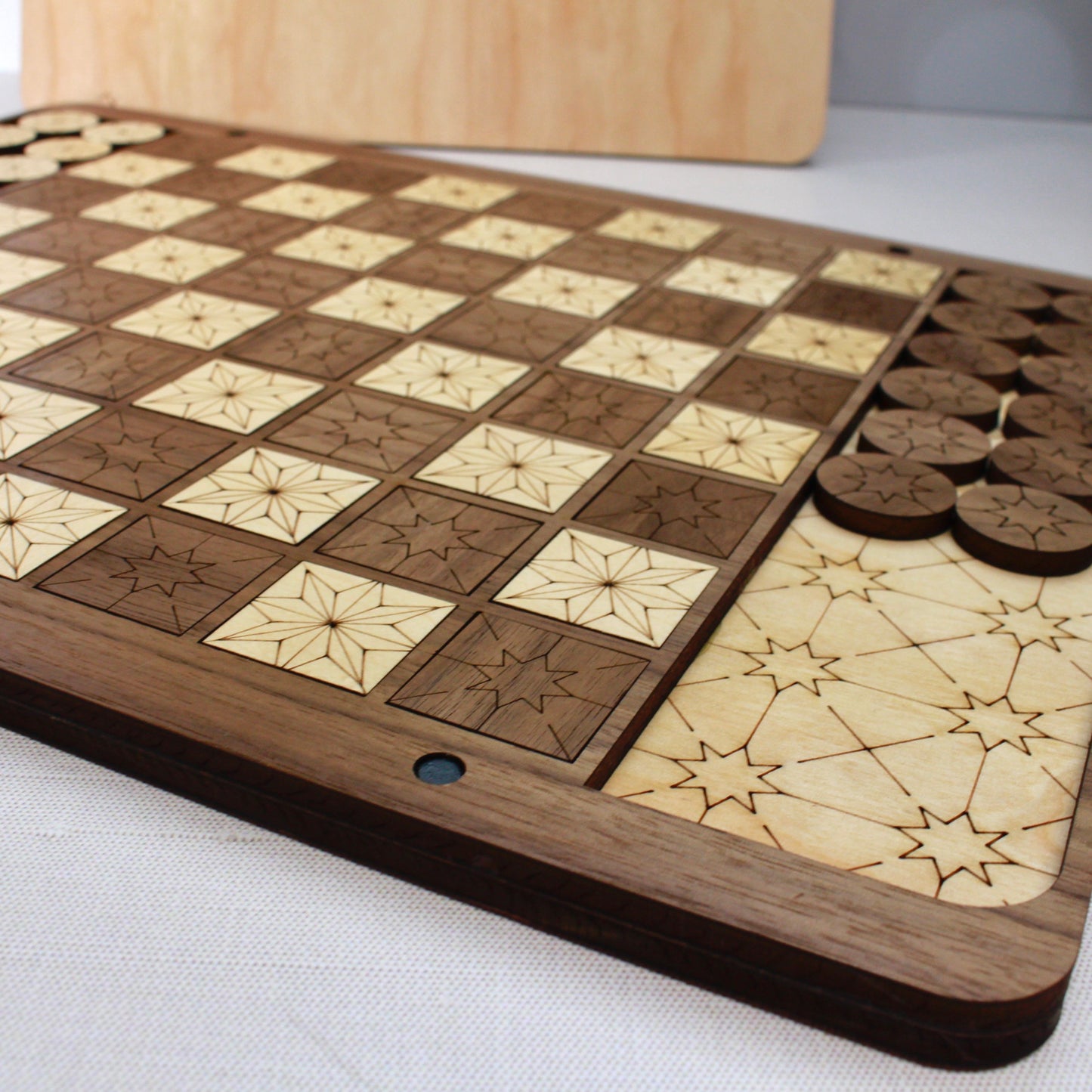 Foxwood Engraving handcrafted wooden Checkers game displayed on marble table.