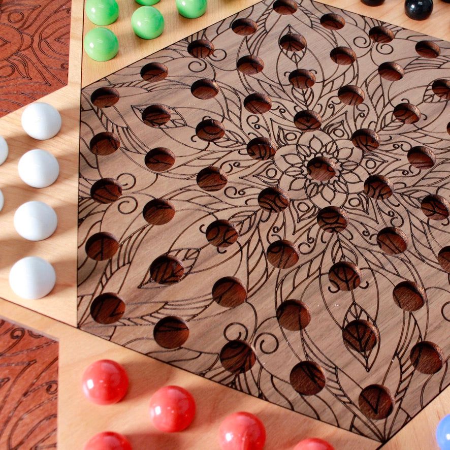 Colorful glass marbles arranged on handcrafted Chinese Checkers game board.