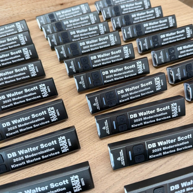 Rows of black rechargeable work lights personalized for DB Walter Scott and the Kiewit Marine Services 2025 modernization project