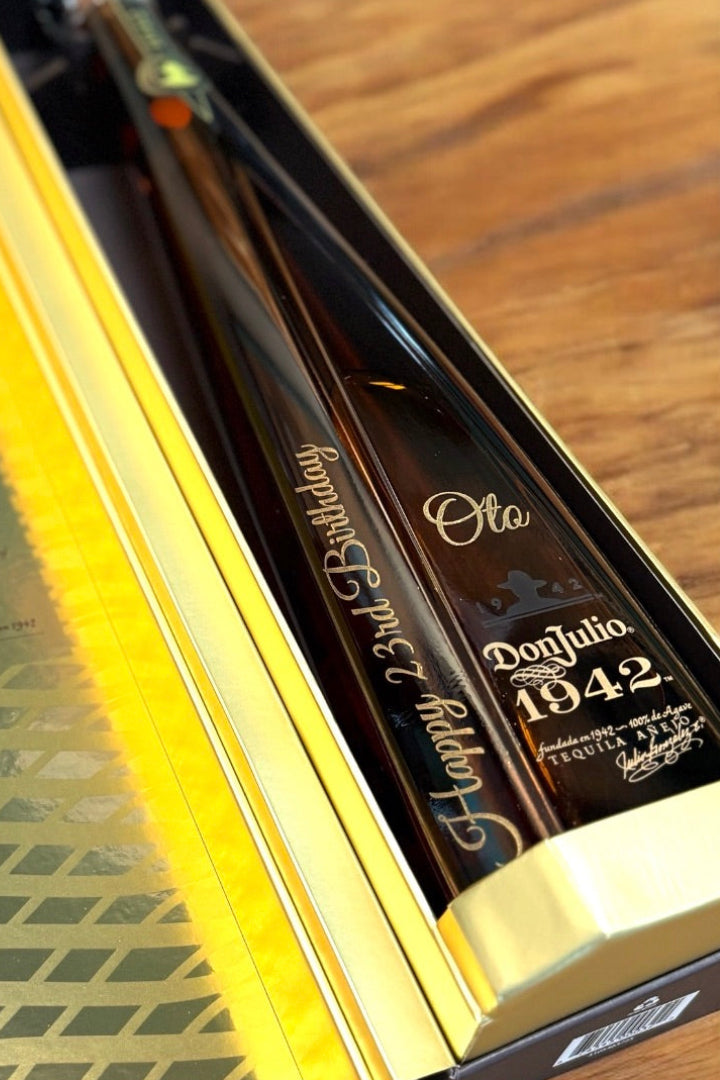 Close-up of a Don Julio 1942 tequila bottle engraved with a milestone birthday message and name.