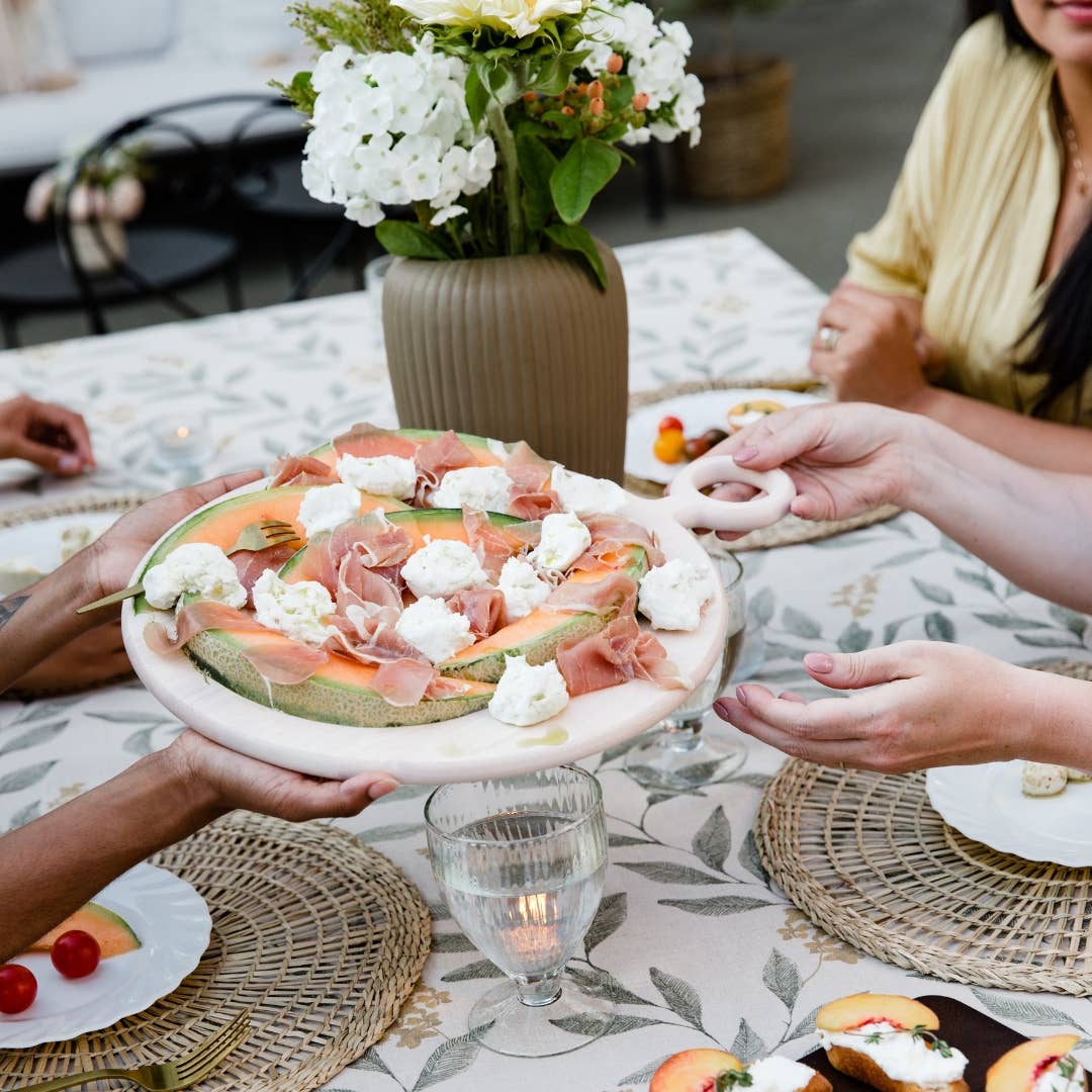 Round wooden charcuterie board for cheese, meats, and snacks.
