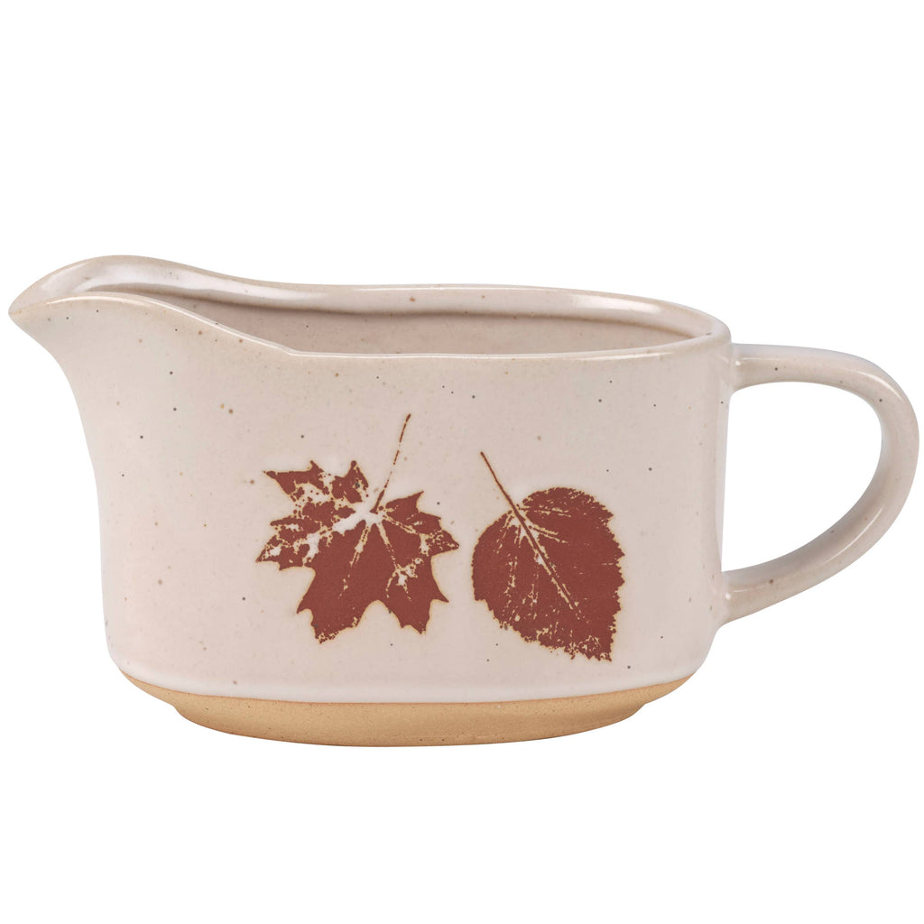 Rustic ceramic gravy pitcher with autumn leaf motif and bare base.
