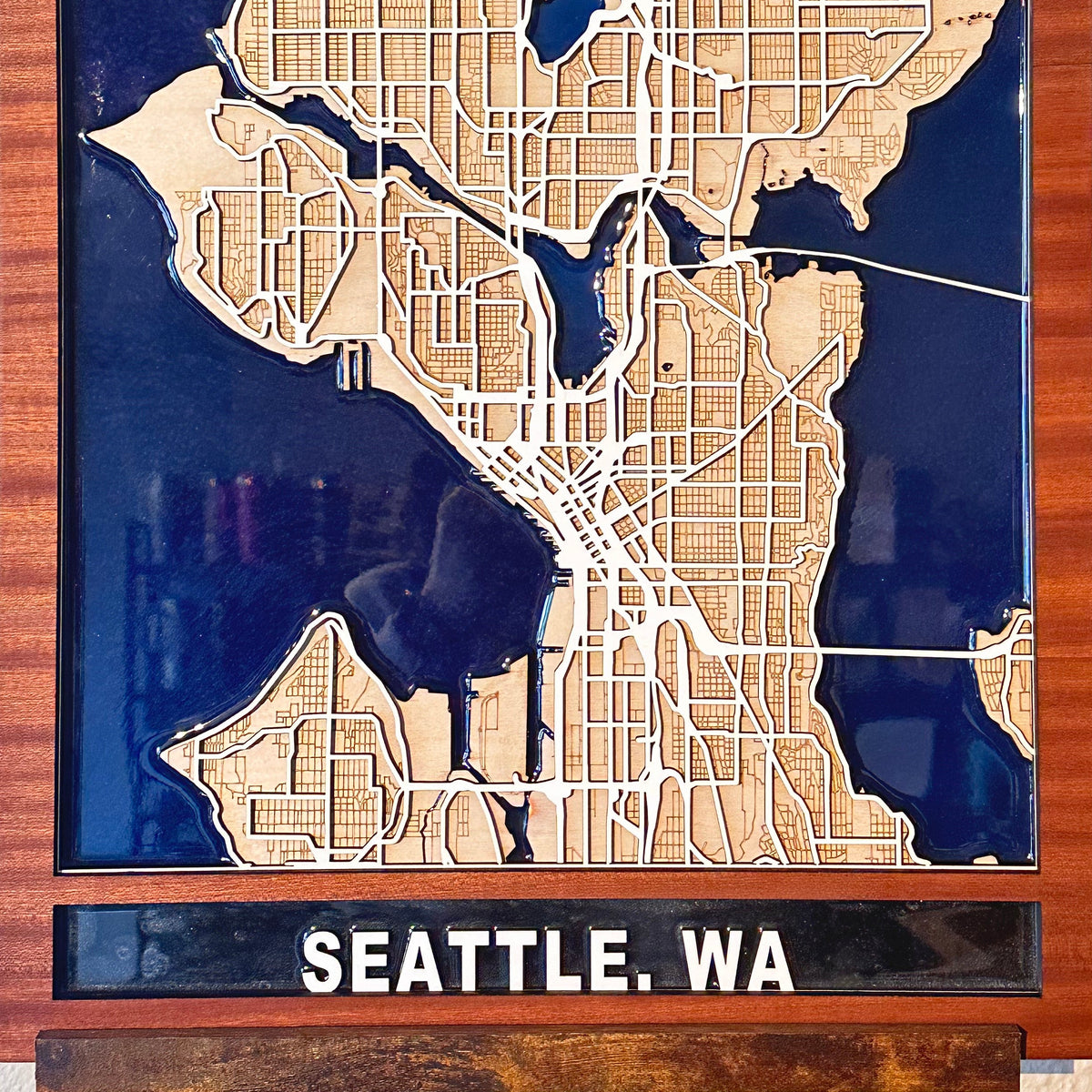 Dimensional Seattle street map wall art combining precisely cut wood with deep blue resin waterways