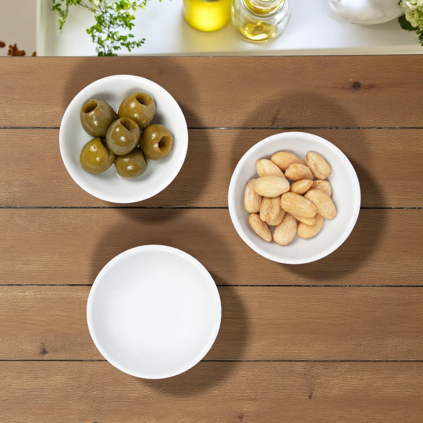 Set of small white ceramic serving bowls for snacks and sauces.