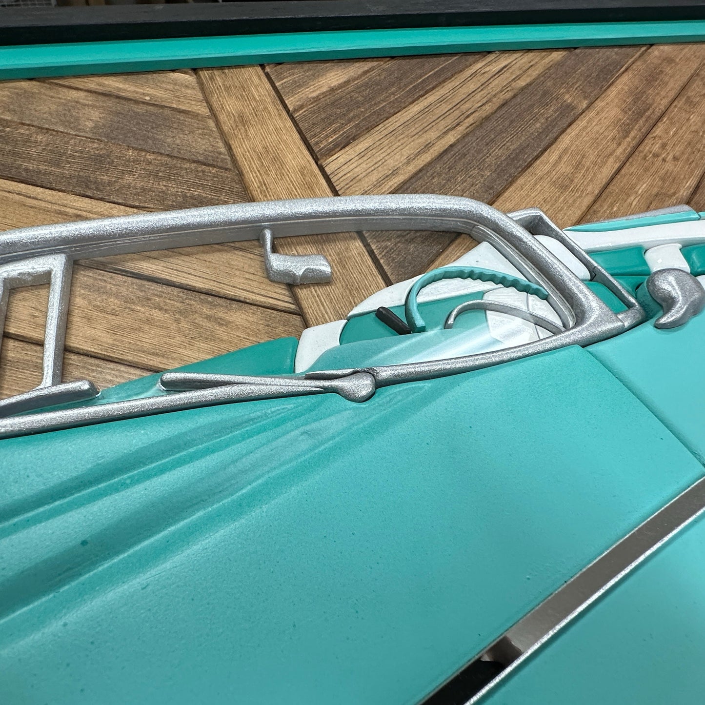 Hand-painted turquoise and chrome 1957 Chevy Bel Air art mounted on wood mosaic background.