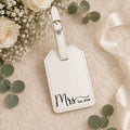 White leatherette luggage tag engraved with Mrs and wedding date in gift box.