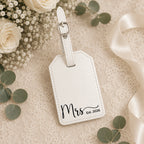White leatherette luggage tag engraved with Mrs and wedding date in gift box.