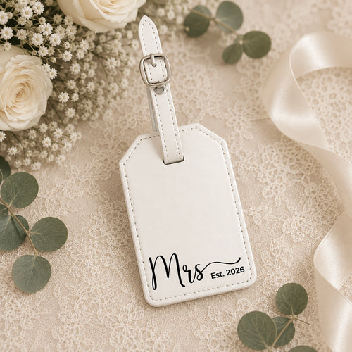 White leatherette luggage tag engraved with Mrs and wedding date in gift box.