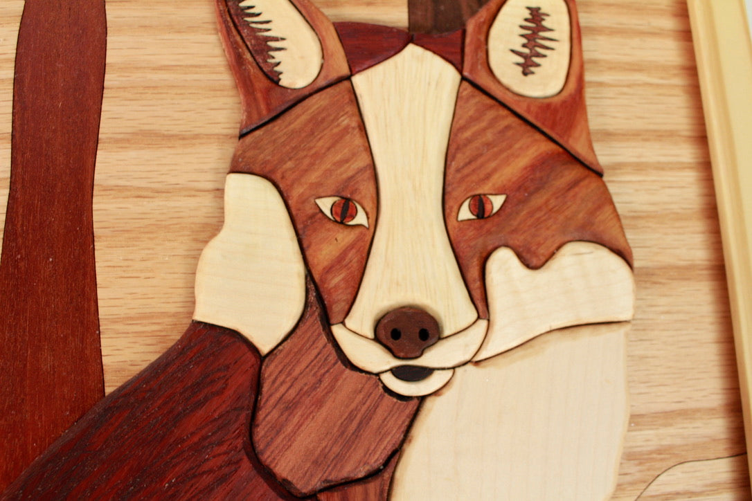 Framed woodland fox intarsia artwork assembled from contrasting natural woods.